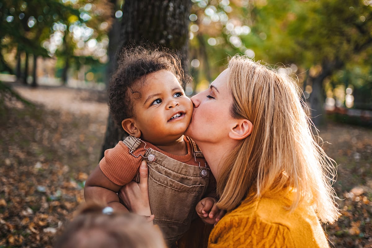 Mother kissing adopted child in Jacksonville family law case