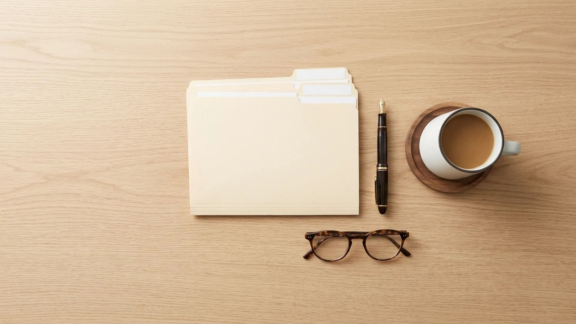 Organized folders, pen, glasses, and coffee laid out on a desk in preparation for custody mediation
